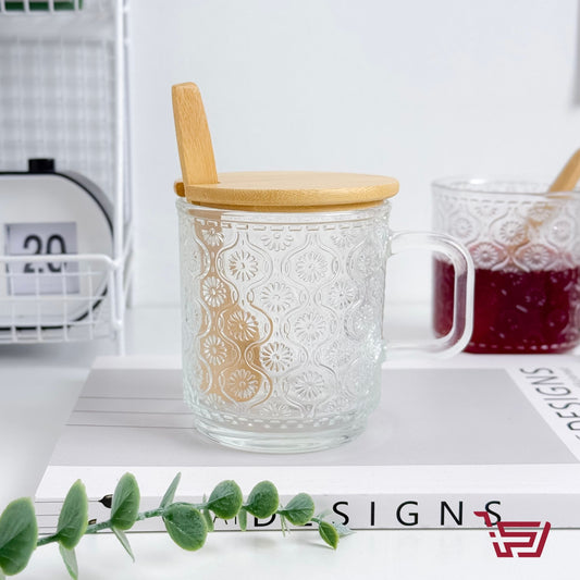 كوب زجاجي بزخرفة مع غطاء وملعقة خشبية