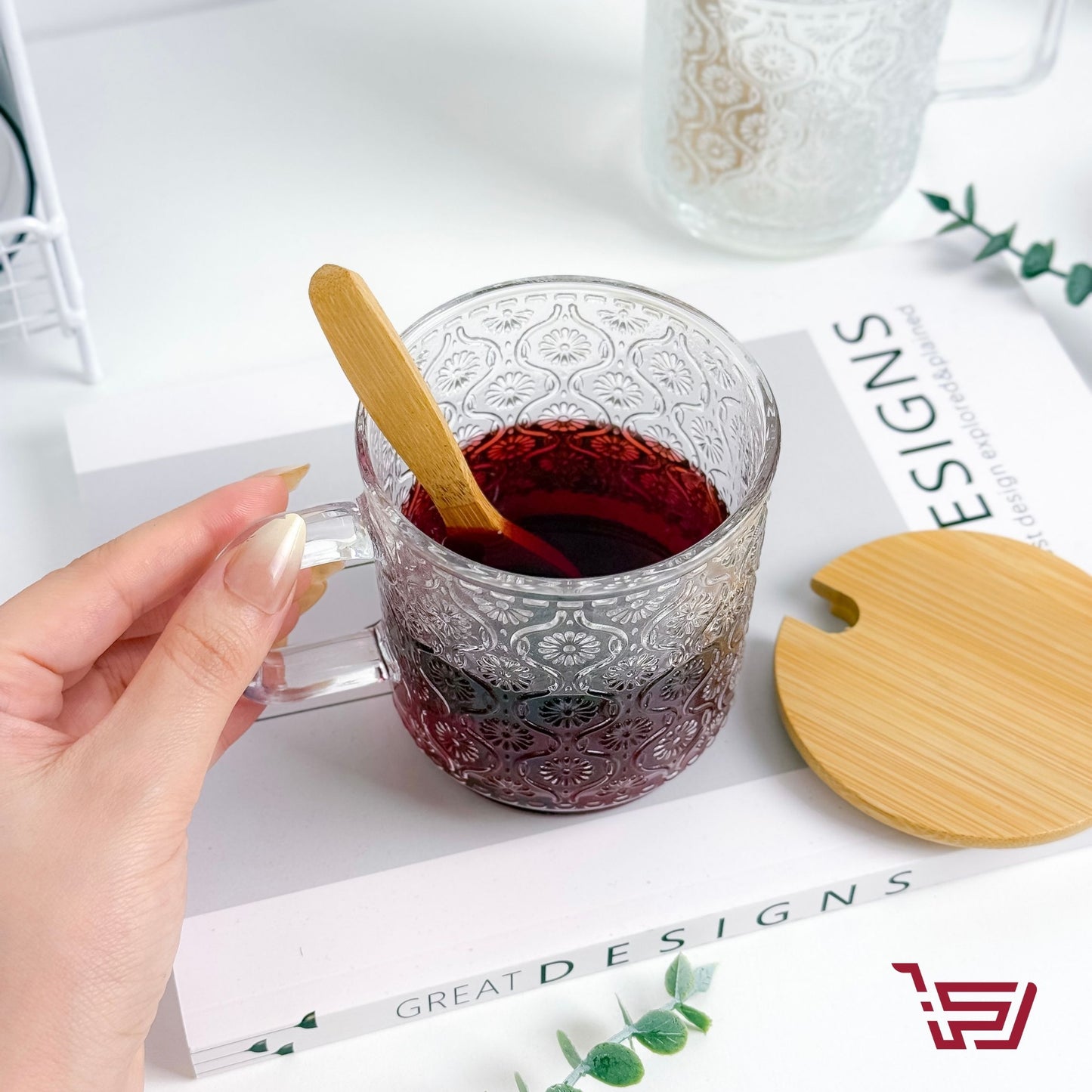 كوب زجاجي بزخرفة مع غطاء وملعقة خشبية