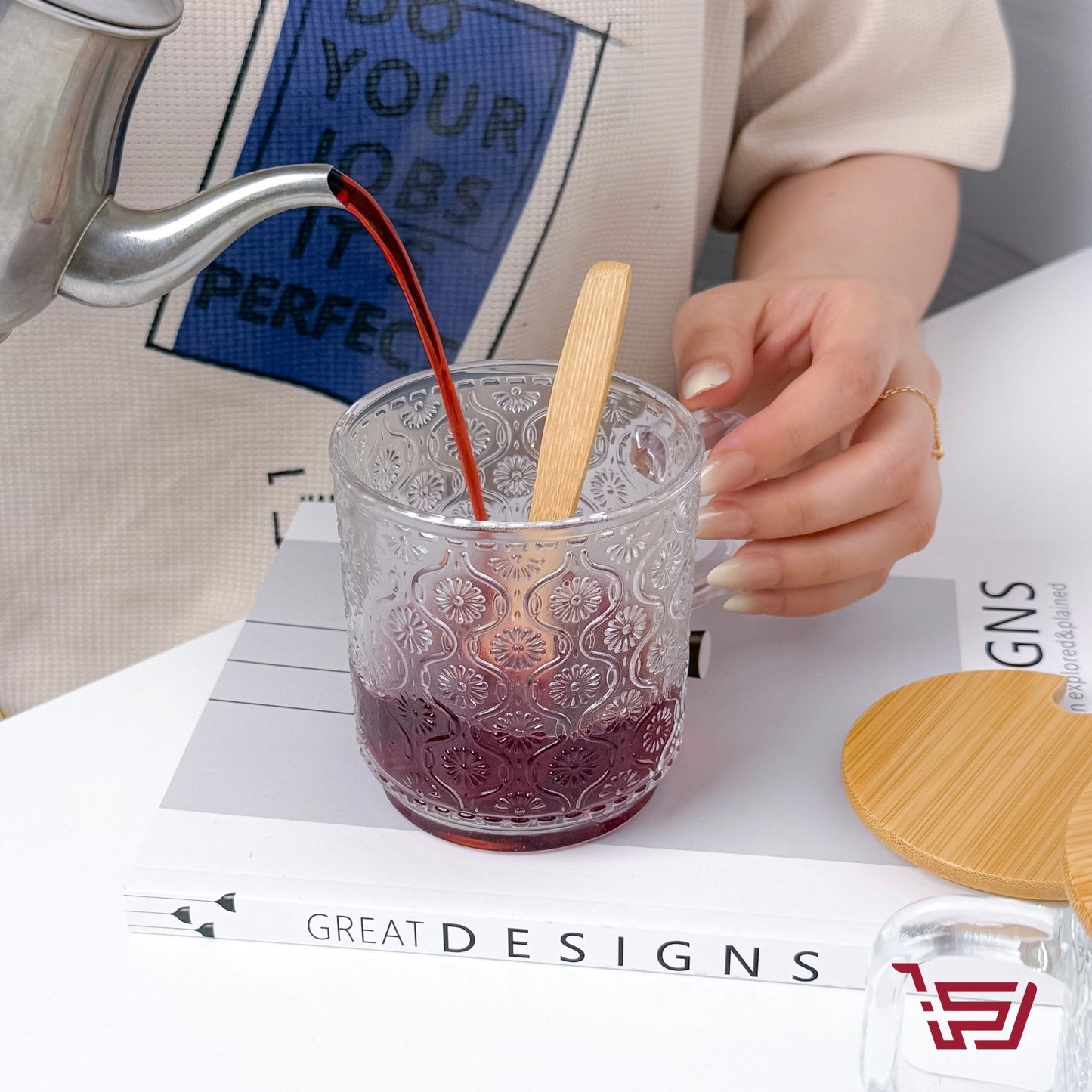 كوب زجاجي بزخرفة مع غطاء وملعقة خشبية